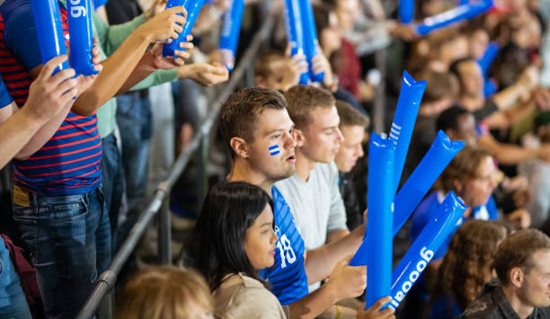 istock Cheering Fans With Blue Banging Thundersticks 1191240114