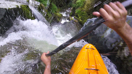 Kayakde de agua blanca rema por la cascada photo