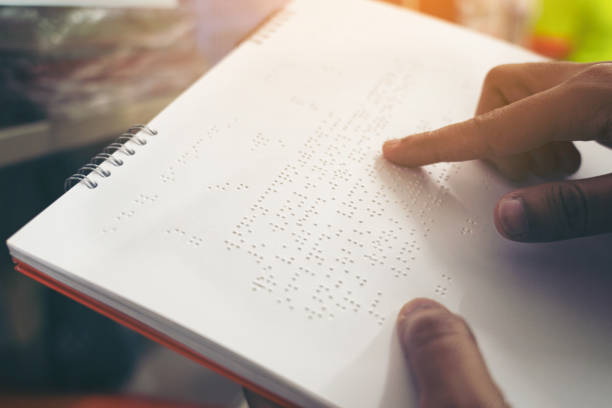Close-up of fingers reading braille, Hand of a blind person reading some braille text of a braille book. Close-up of fingers reading braille, Hand of a blind person reading some braille text of a braille book. assistive technology photos stock pictures, royalty-free photos & images