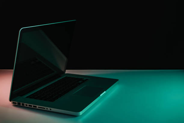 istock Beautiful silver laptop in the color light on a table and night background. 1191243812
