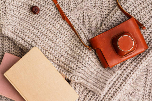 istock Books and a retro camera on a wool sweater 1191246357