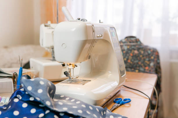 istock fabric and ready-to-use sewing machine on a table in a room 1191246853