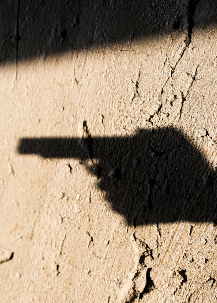 istock Shadow of the hand pointing a gun 1191249401