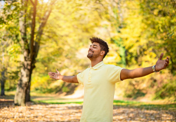 istock Happy young man relaxing in nature with arms open. 1191250694