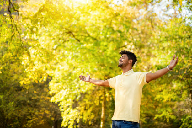 istock Happy young man relaxing in nature with arms open. 1191250770