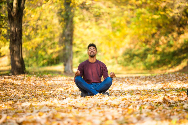 istock Young man meditating in nature on autumn day. 1191251693