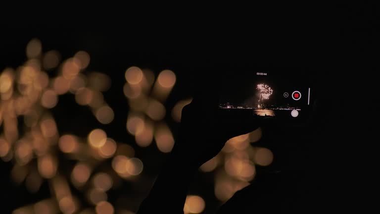 4K Slow motion New year festival Asian women She is using a mobile phone to photograph fireworks during the end of the year celebration.