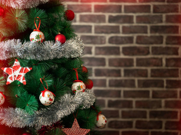 istock Beautifully decorated Christmas tree with gift boxes near brick wall 1191254388