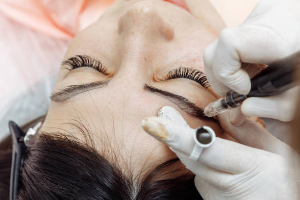 istock Permanent makeup, tattooing of eyebrows. Cosmetologist applying make up 1191255739