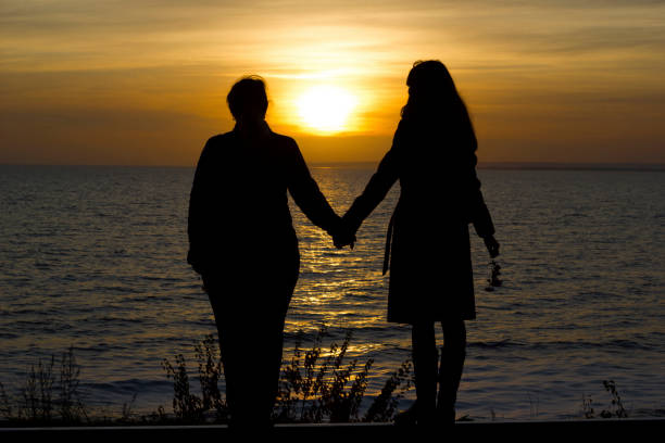 istock Girlfriends standing on railway rails holding hands on sunset background 1191256027