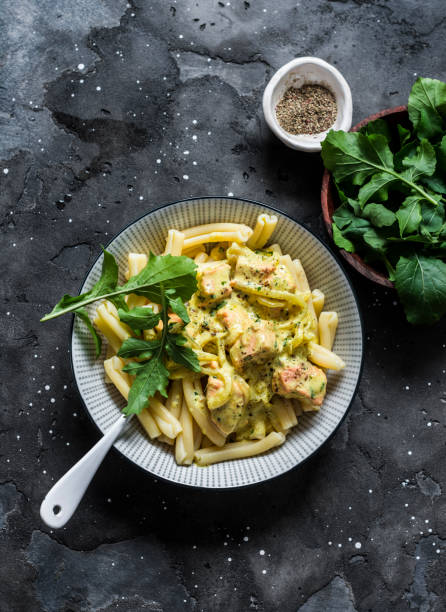 istock Curried creamy salmon with pasta on a dark background, top view 1191257471