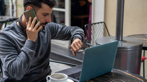 istock man drinking coffee and looking at the computer in front of his watch 1191262905