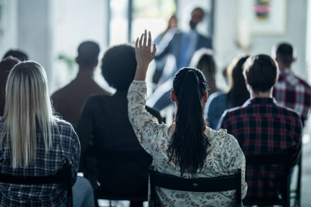 istock Back view of creative woman asking a question on education event in the office. 1191262952