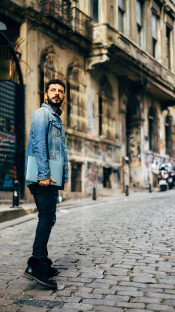 istock men on the street with computer/istanbul 1191264278