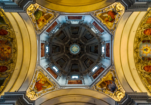 Symmetrical interior shot of masterful vibrant ceiling of Salzburg cathedral in Austria