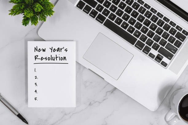 istock New Year's Resolution List on Notebook With Laptop. 1191266022