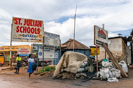 Shop and education signs after a rainstorm, along the highway near Kabubbu, north of Kampala, Uganda November 2019