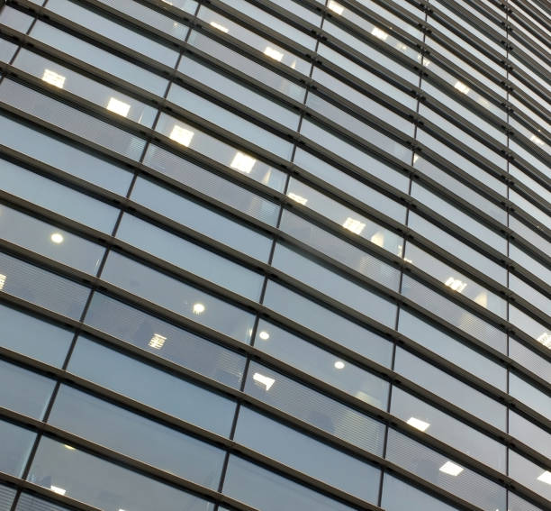 istock illuminated windows on the facade of a large curved modern office building with lights turned on on at twilight 1191266889