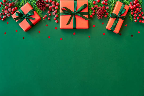 istock Christmas flat lay background with fir tree, present box and decorations on green. Free space for design. 1191266977