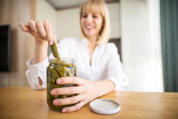 istock Pregnant woman eating pickles in kitchen 1191267207