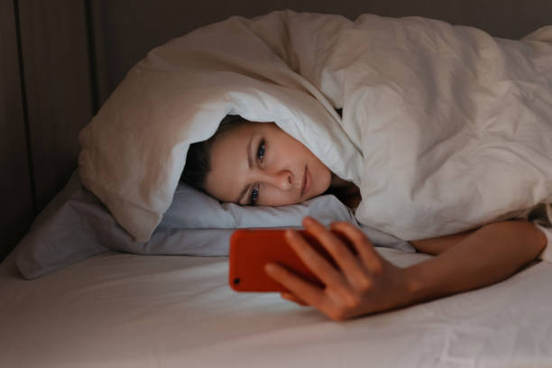 istock Young woman can't sleep and using her smartphone in beg at night. 1191268405