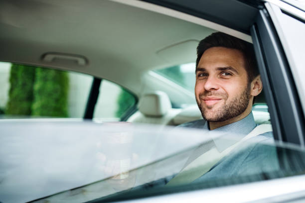 istock Businessman with coffee sitting on back seat in car. 1191268421