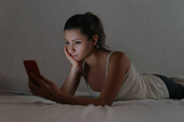 istock Young female using her smartphone in bed at night instead sleeping. 1191268484