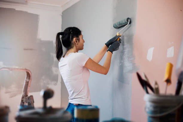 mujer joven con audífonos pintando paredes - repairing apartment home improvement painting fotografías e imágenes de stock