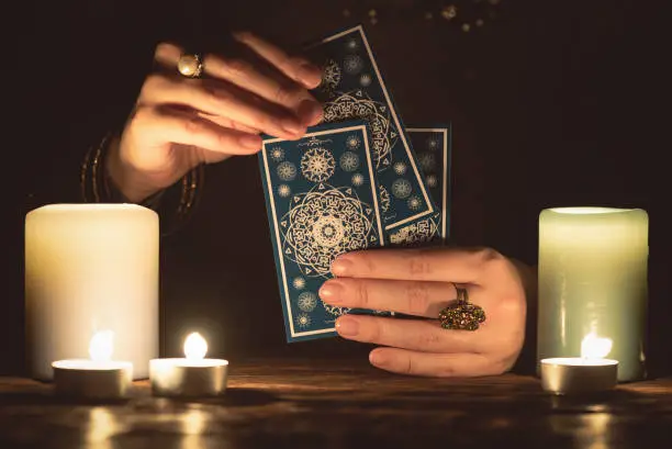 Fortune teller with tarot cards in hands close up. Future reading concept.