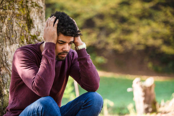 istock Depressed young man sitting alone in nature. 1191270841