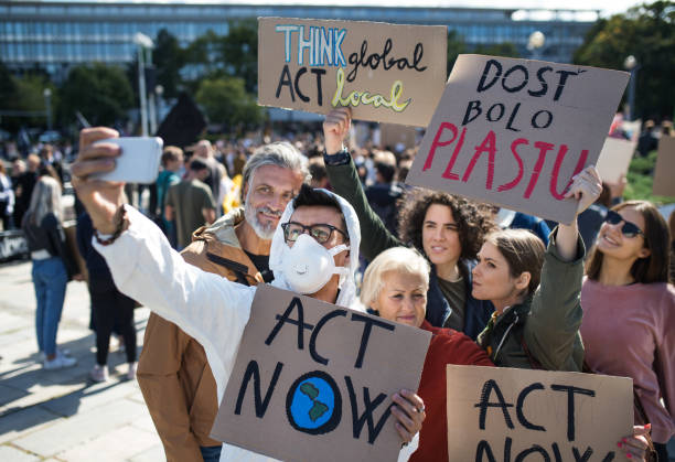 istock People with placards and protective suit on global strike for climate, taking selfie. 1191271780