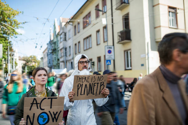 istock People with placards and protective suit on global strike for climate change. 1191271950