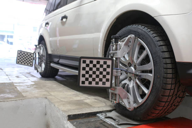 istock auto mechanic sets the car for diagnostics and configuration. Wheel alignment equipment on a car wheel in a repair station.3d tie rod balancing 1191271967