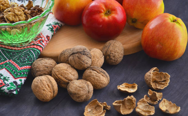 istock Ripe apples and walnuts on the table. Peeled nuts and shelving from them. 1191273999