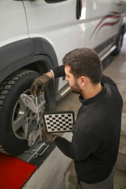istock auto mechanic sets the car for diagnostics and configuration. Wheel alignment equipment on a car wheel in a repair station.3d tie rod balancing 1191275372