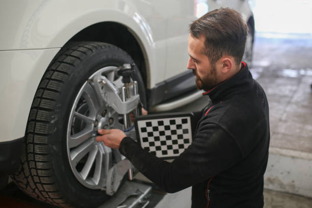 istock auto mechanic sets the car for diagnostics and configuration. Wheel alignment equipment on a car wheel in a repair station.3d tie rod balancing 1191275406