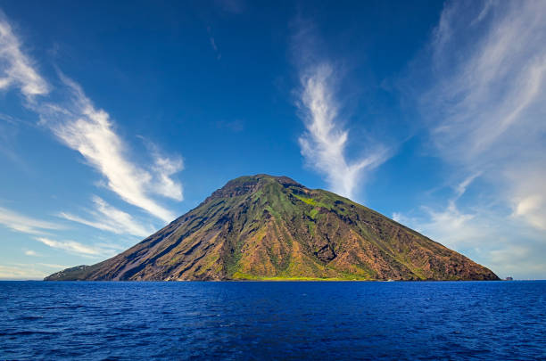 вулканический остров стромболи в липари рассматривается из океана с красивыми облаками, сицилия - вулканология стоковые фото и изображения