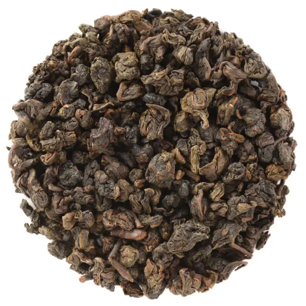 High grade dry leaf tea in round shape. Mingjian Organic Master Spring Charcoal Roasted Oolong Tea isolated on white background overhead view