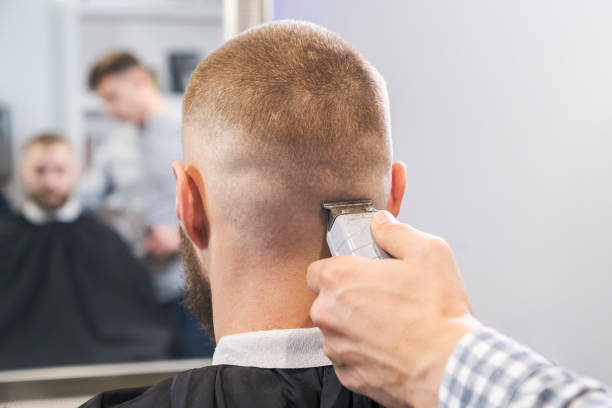 istock Barber shaves the client's head with a red electric trimmer. selective focus 1191285005