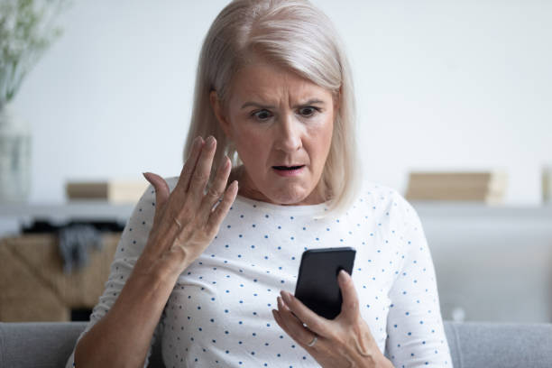 istock Mad elderly woman holding smartphone having problem with gadget 1191287538