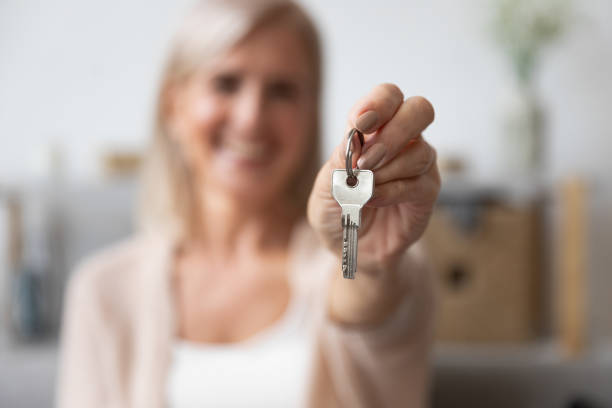 istock Close up focus on aged female hand holding key 1191287589