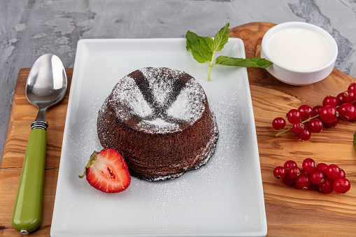 Close up Photograph of a chocolate souffle. Chocolate fondant lava cake with strawberries.