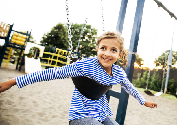 istock Girl on a Swing at a Public Park 1191291167