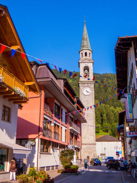 Pinzolo, Italy - August 28, 2018: View of the downtown with the bell tower of the Church of San Lorenzo (St. Lawrence) in the background.