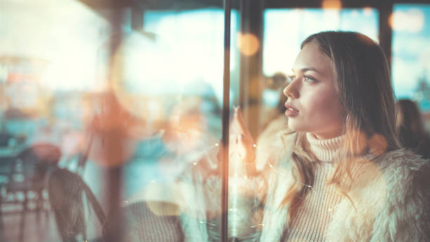 istock Side view of thoughtful woman looking through window 1191312534