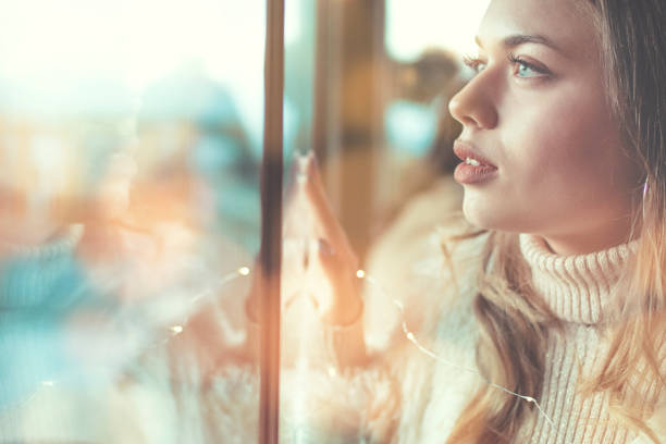 istock Side view of thoughtful woman looking through window 1191312561