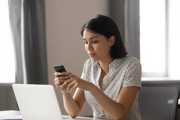 istock Serious Asian businesswoman using mobile phone at workplace 1191319765