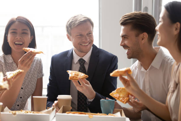 istock Happy diverse employees colleagues sharing meal at lunch break 1191319924