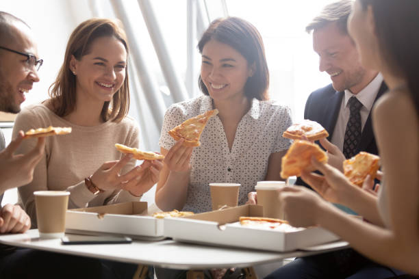 istock Happy diverse employees enjoying pizza, having fun during break together 1191319928