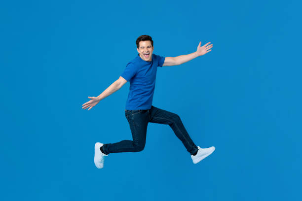 istock Energetic handsome man jumping and smiling with outstretched hands 1191320067